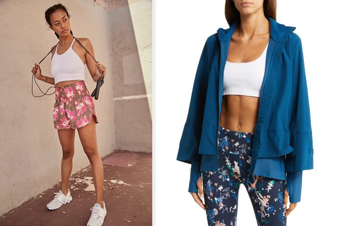 A model poses wearing a cropped halter white top paired with brown, pink, and white floral shorts and white sneakers against a brown wall. Another model sports a layered blue jacket over a white sports bra and navy, green, white, and peach splattered leggings.