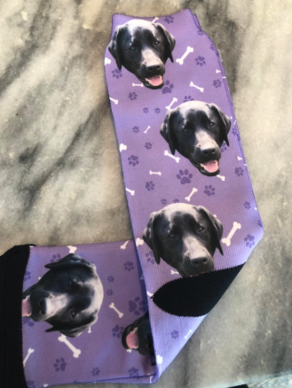 A pair of purple socks showcasing the cute face of the reviewer's dog, making it feel like their pet is always close by.