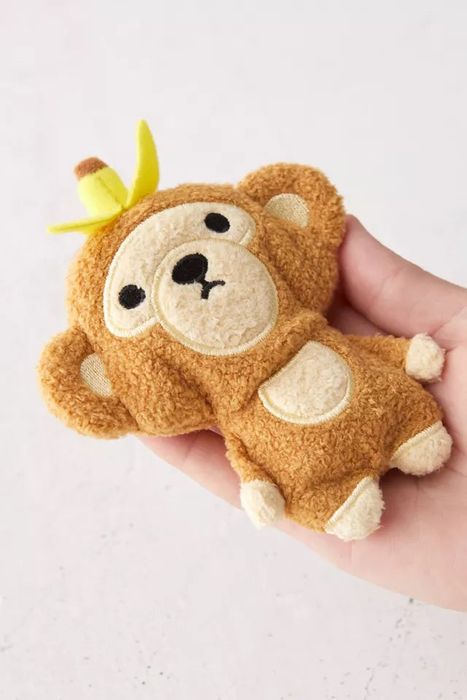 A hand holding a plush monkey toy.