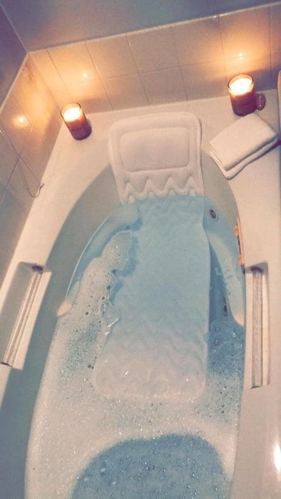 a long bath pillow in a bubbly tub