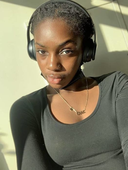 A reviewer wearing the black headphones.