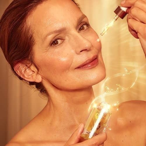 A model applying a rejuvenating serum to her face.