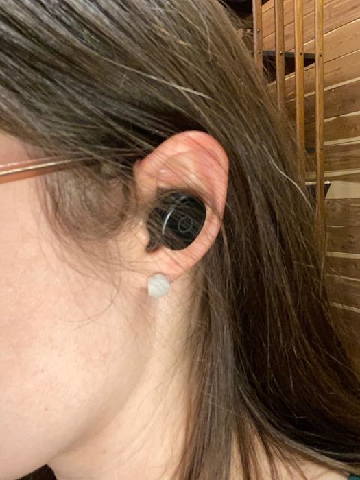 Reviewer wearing the wireless earbuds