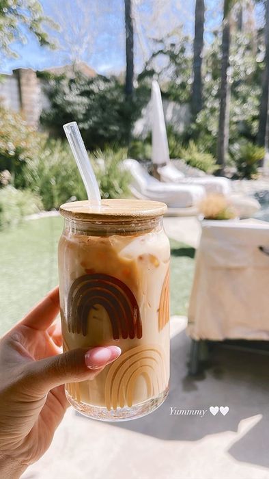 A glass coffee cup adorned with tan and brown rainbows.