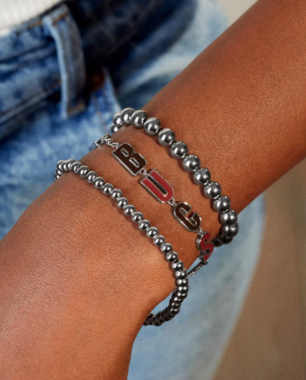 A model wearing a delicate chain bracelet that spells out