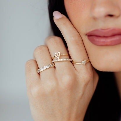 A model showcasing a collection of earrings, including a sweet open heart design.