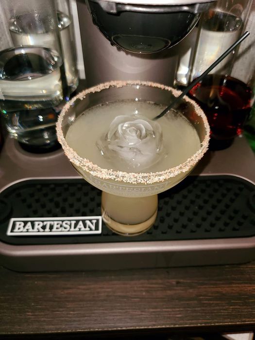 a beverage with a rose-shaped ice cube floating in it
