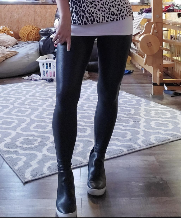A reviewer rocking black faux-leather leggings.