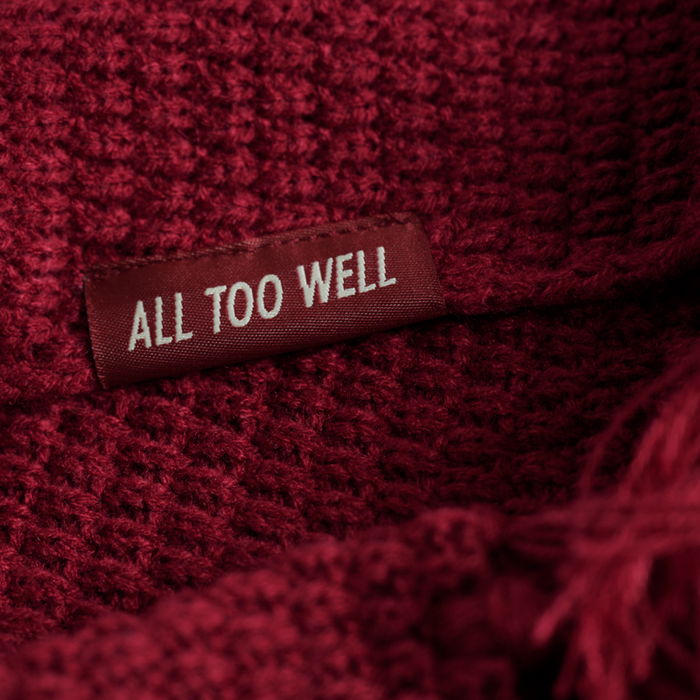 A close-up of the 'All Too Well' detailing on the scarf.