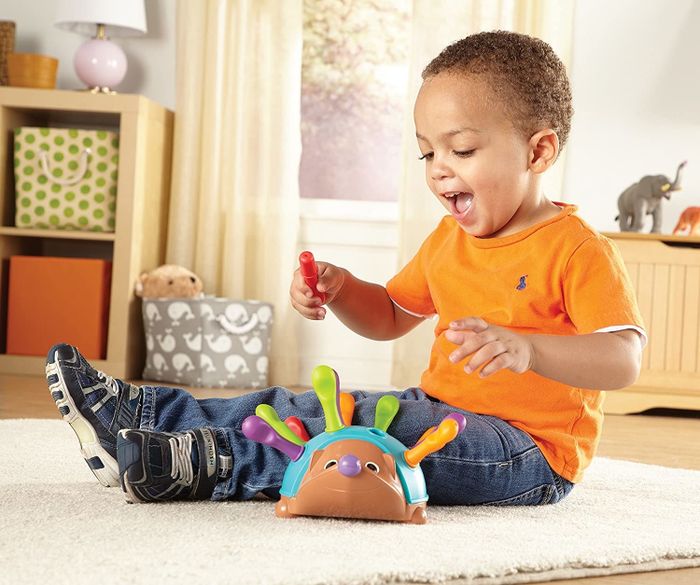 a child engaging with the hedgehog toy, enjoying its interactive features