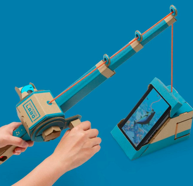 A child enjoying the Switch while using a DIY fishing rod to 'fish'