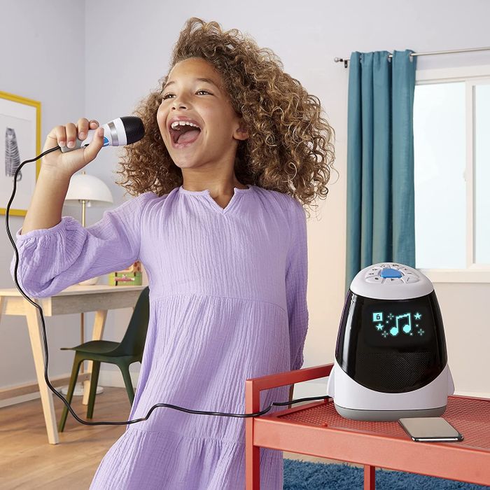 a child performing a karaoke song with the machine