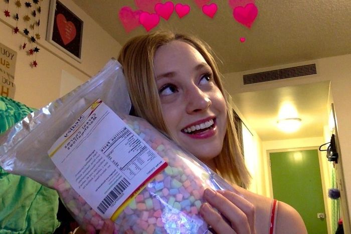 A reviewer happily holding a bag of cereal marshmallows, ready to indulge in the marshmallow-filled goodness.