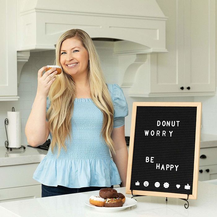 A model posing next to the letter board, showing off a creative expression.