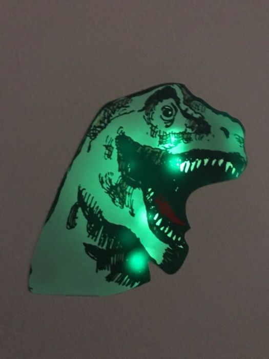 A photo shared by the reviewer showing a glowing dinosaur decal on the wall