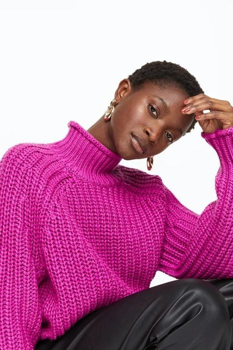 A model dressed in a striking fuchsia sweater.