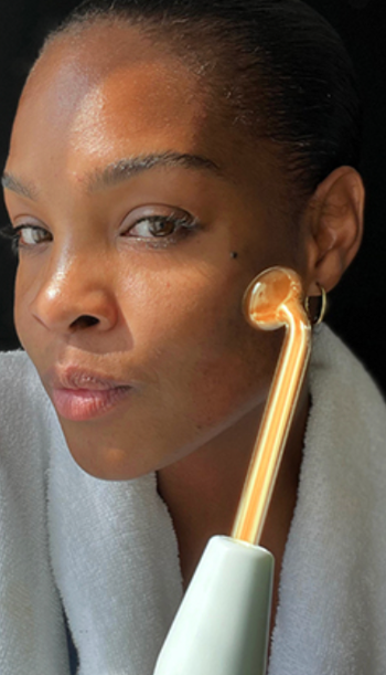 A person uses a facial roller on their cheek, enhancing their skincare and beauty routine.
