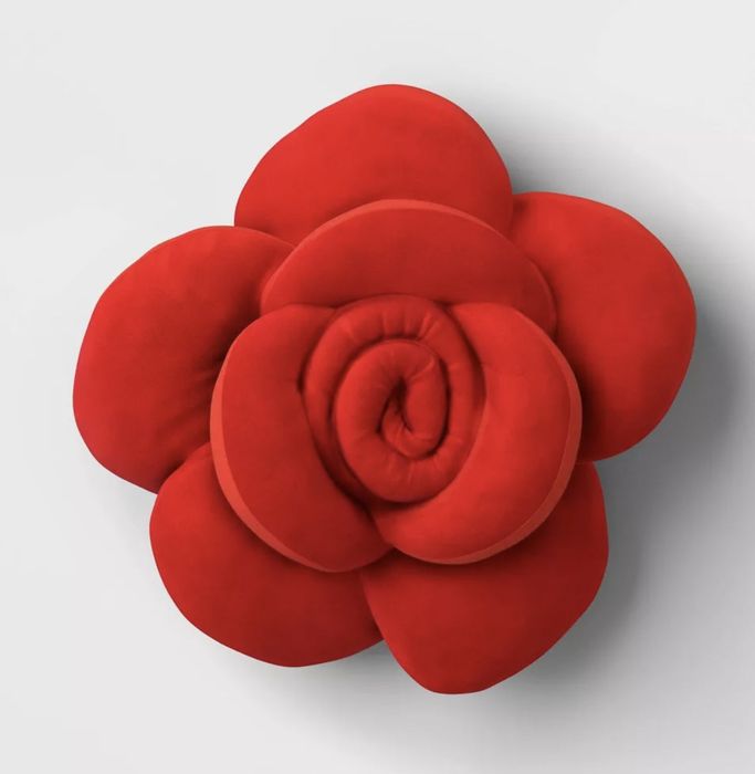 A plush pillow designed to look like a blooming red rose.
