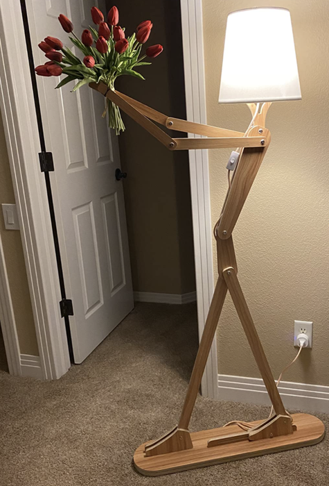 A reviewer’s lamp holding a bouquet of bright red tulips