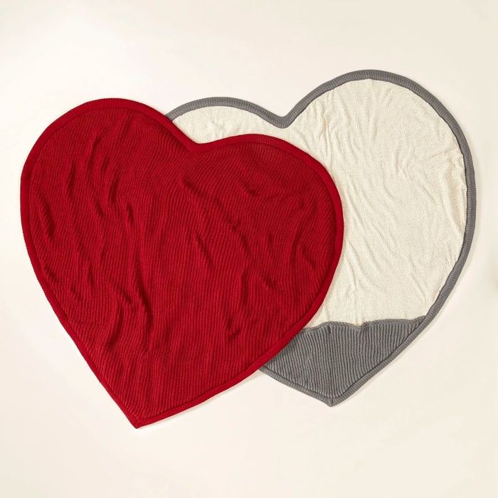 Heart-shaped blankets in red and gray with cream fleece on one side and a cozy foot pocket at the bottom.