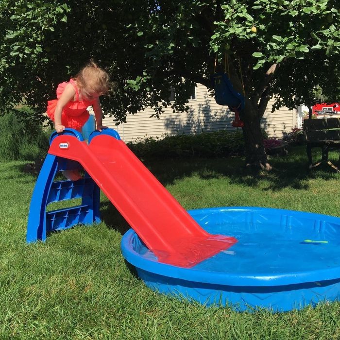 Reviewer’s photo of their child using the red slide in a pool.