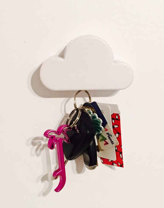 A reviewer's photo of the cloud-shaped magnetic key holder with a set of car keys attached to the wall