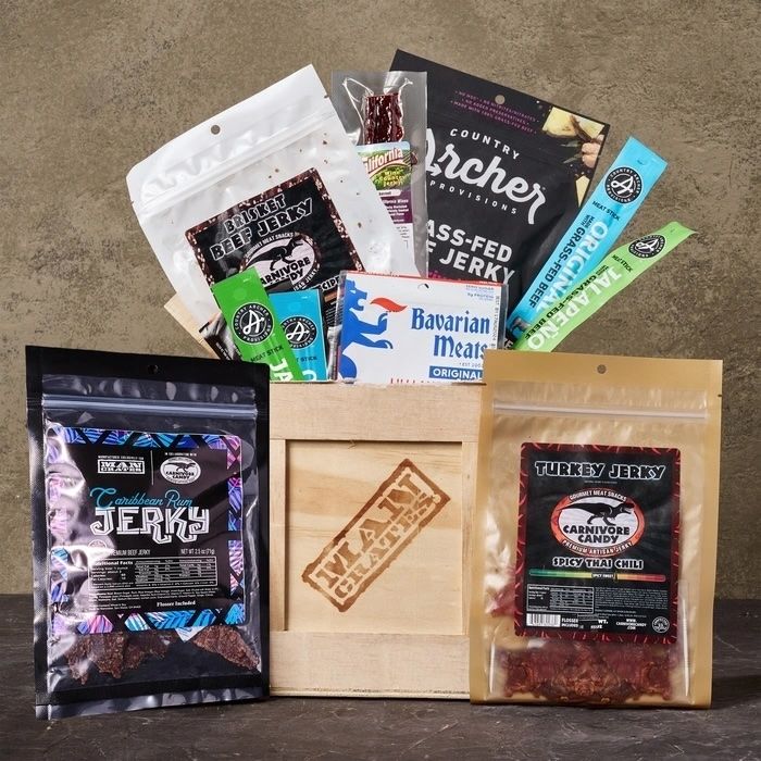 A wooden crate overflowing with a variety of beef jerky and other meat snacks