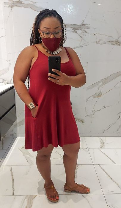 A reviewer’s mirror selfie showing someone wearing the red tank dress paired with a matching face mask.