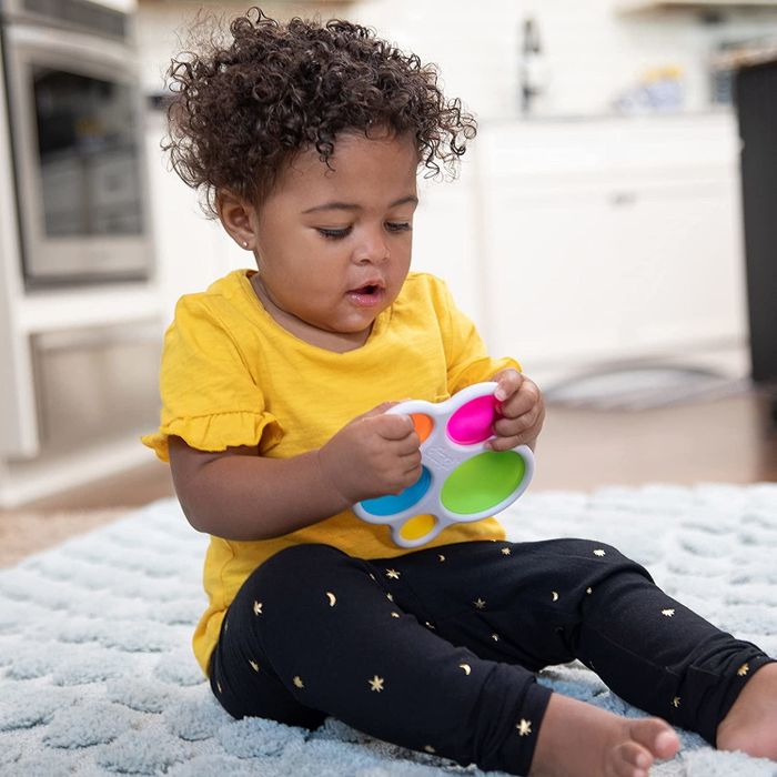 A child playing with the fidget toy in their hands.