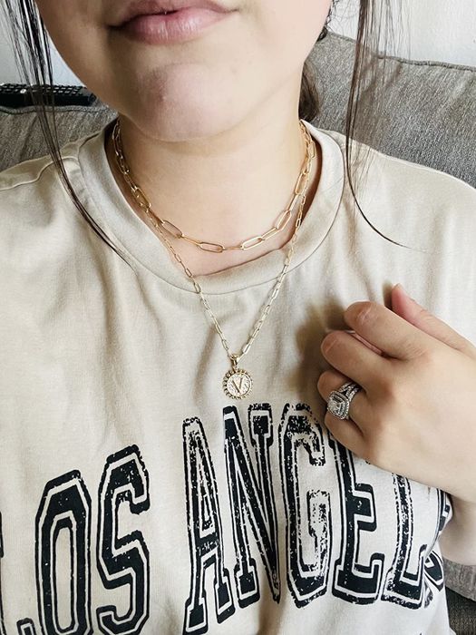 A reviewer sporting the same necklace set, this time featuring the letter charm