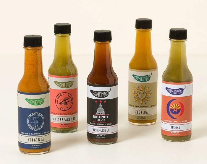 Five bottles of hot sauce labeled Virginia, Chesapeake Bay, Washington DC, Florida, and Arizona, arranged for a neat display.