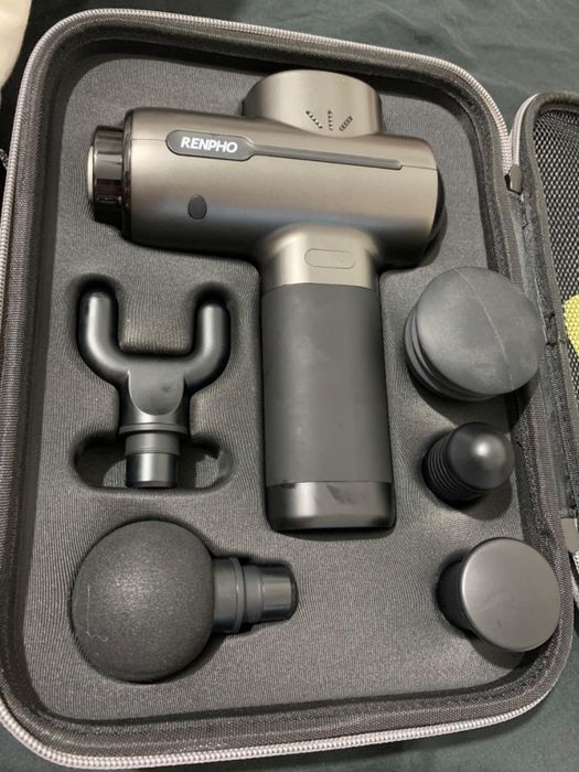 A massage gun set with multiple attachments stored in a sleek black case.