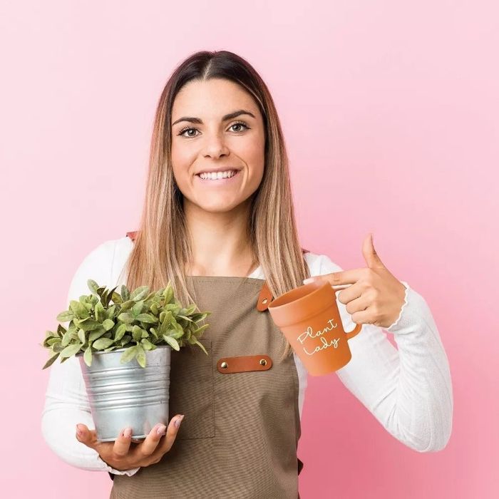 A model holding the 'Plant Lady' mug, showing off its plant-inspired design.