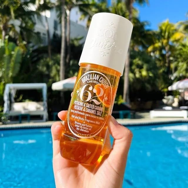A hand holding a bottle of Sol de Janeiro Cheirosa '62 hair perfume.