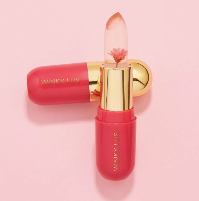 The pink lipstick tube is open, showcasing the flower inside.