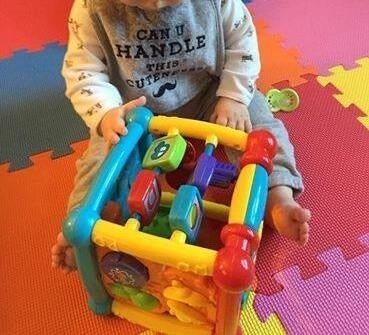 A photo from a reviewer showing their baby playing with the activity cube.