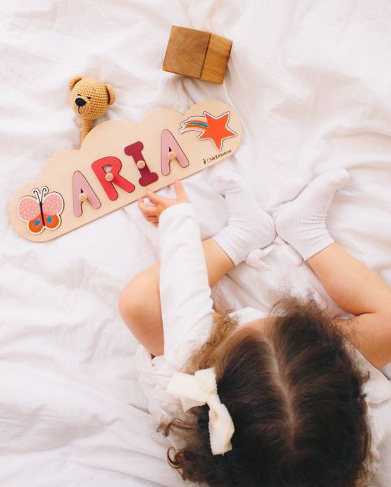 A child having a blast with the wooden name puzzle.
