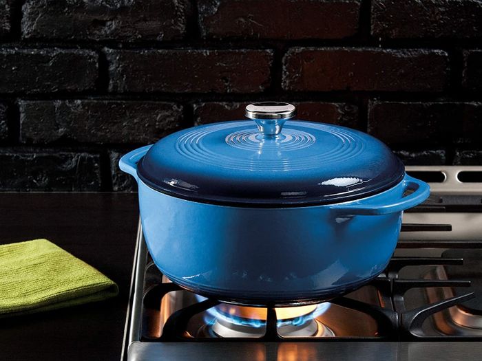 A cast iron pot in blue, resting on a stove, ready for culinary adventures.