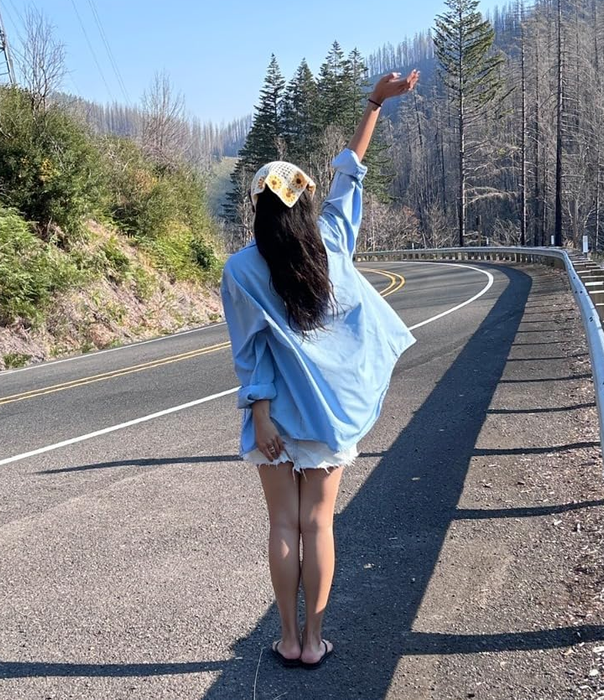 A reviewer styling a white crochet bandana adorned with sunflowers.