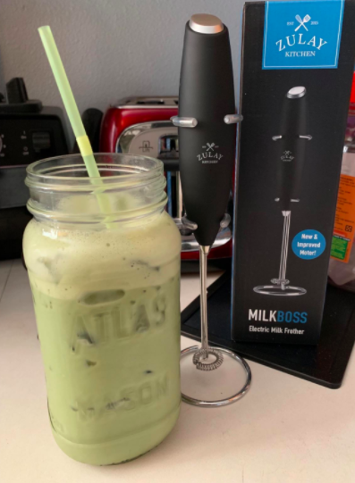 A reviewer using the same milk frother to create an iced matcha latte in their kitchen