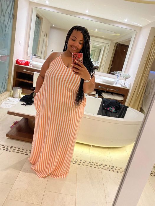 A mirror selfie of a plus-size reviewer wearing the pink-red SheKiss maxi dress.