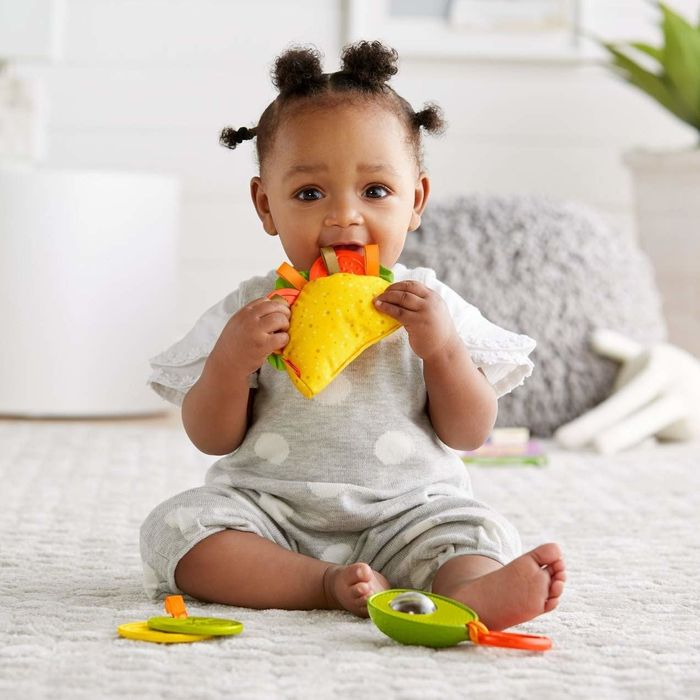 A baby holding a teething toy.