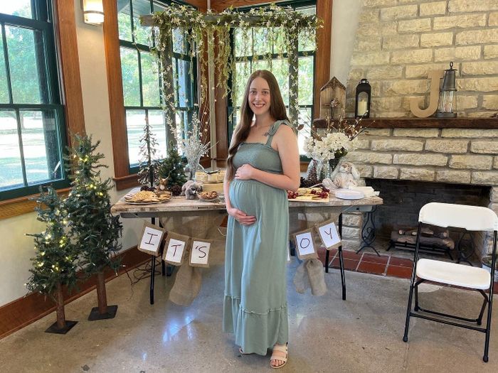 A reviewer wearing a square-neck maxi dress in a soothing sage color