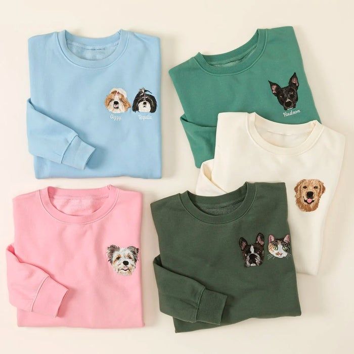 Five folded sweatshirts showcasing various embroidered pet faces