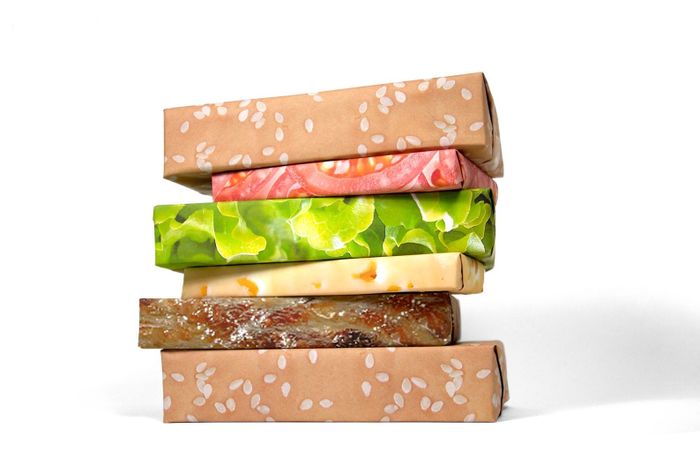 Boxes wrapped in cheeseburger-themed wrapping paper, stacked to look like a cheeseburger