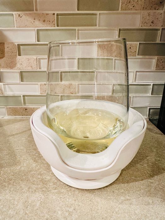 A glass of white wine resting inside the VoChill wineglass chiller, maintaining the ideal temperature.