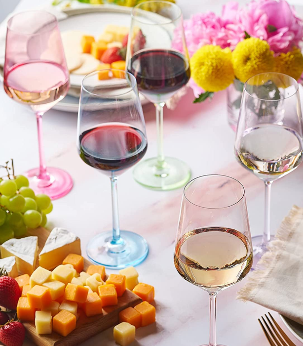 A set of six stemmed wine glasses in soft, translucent pastel hues.