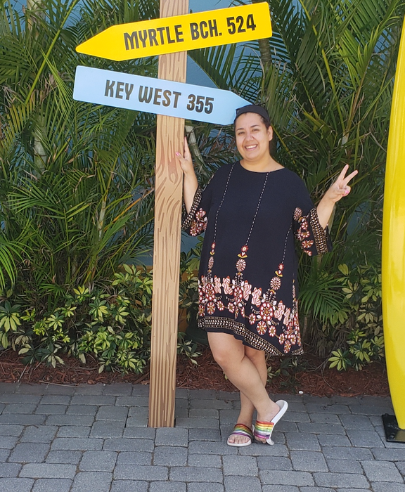 A reviewer is wearing a loose knee-length dress for a comfortable and relaxed look.