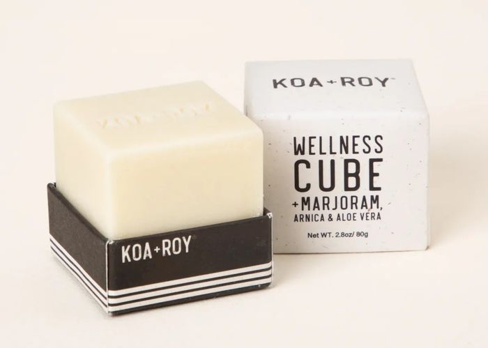 The cream-colored wellness massage cube along with its packaging.