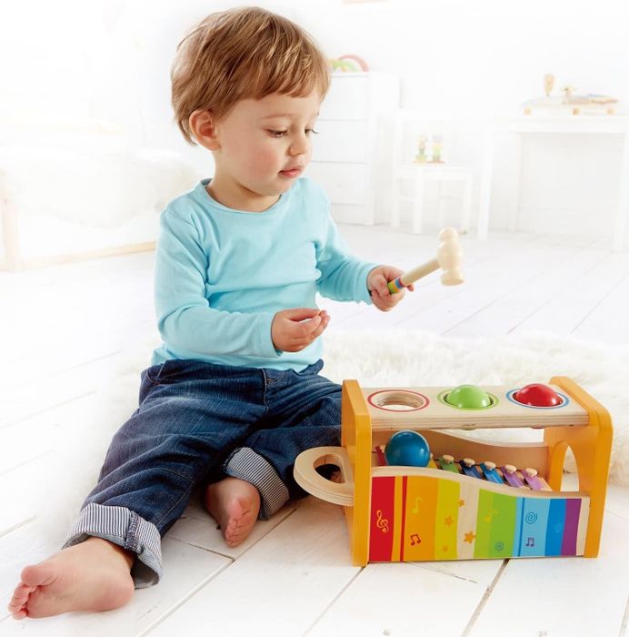 A child enjoying the pound and tap musical bench while playing with the xylophone.